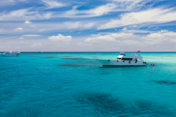 Boat on clear turquoise ocean water.