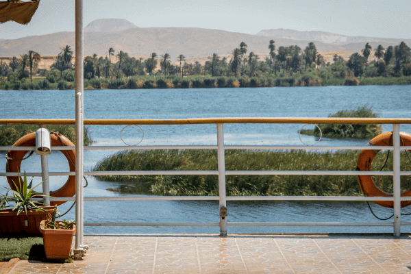 View from a Nile cruise boat overlooking the river and lush greenery in Egypt.
