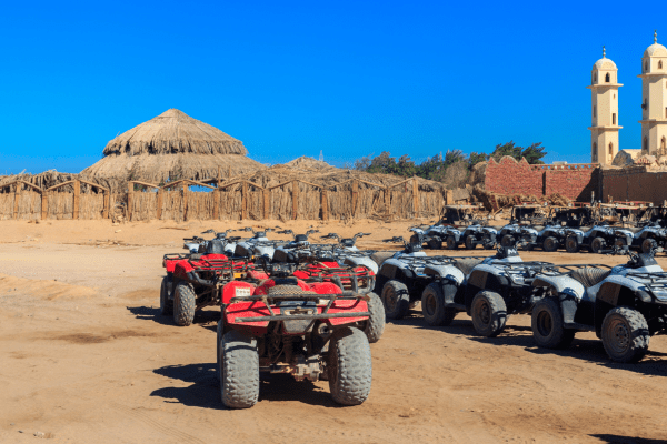 ATVs lined up in desert tour camp.
