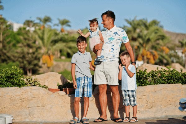 Family posing together in a sunny location in Egypt, with palm trees in the background.