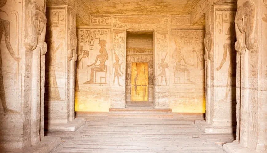 Interior view of an ancient Egyptian temple with hieroglyphics and carved pillars.