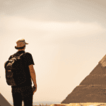 Man observing pyramids, travel adventure concept.