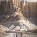 Visitors walking towards a mountainous desert landscape