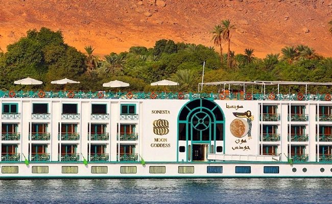 Luxury cruise ship on a river with palm trees